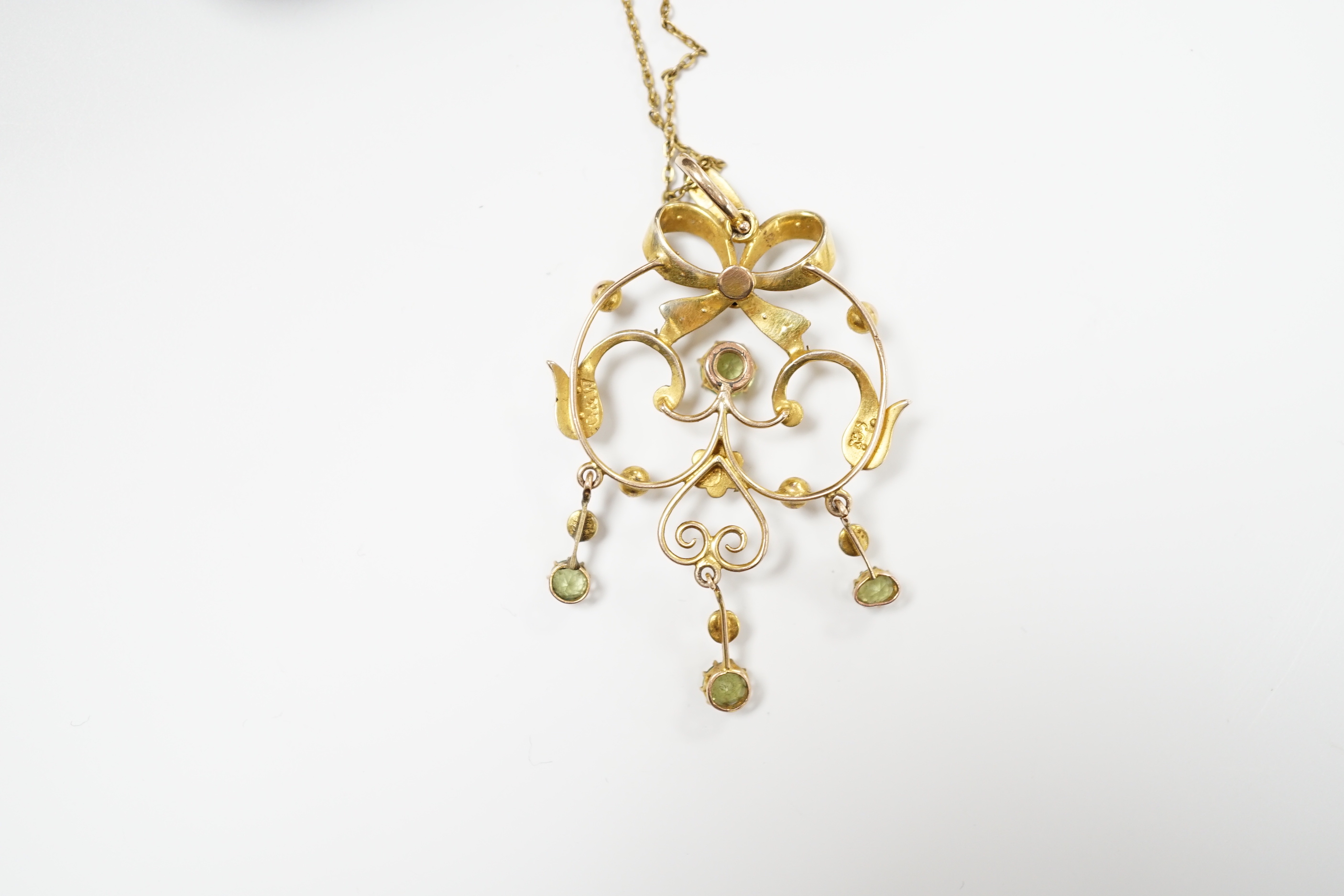 An Edwardian 9ct, peridot and seed pearl cluster set drop pendant, 47mm, on a gilt metal chan.